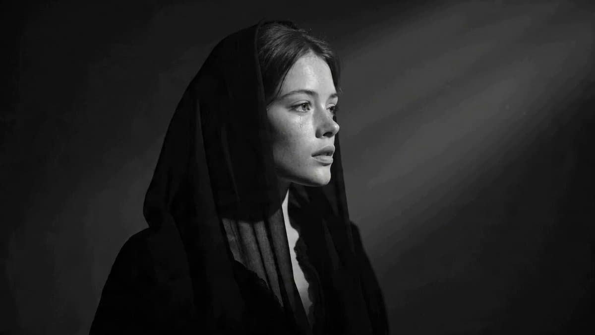 Cinematic black and white portrait of a young woman with a tear